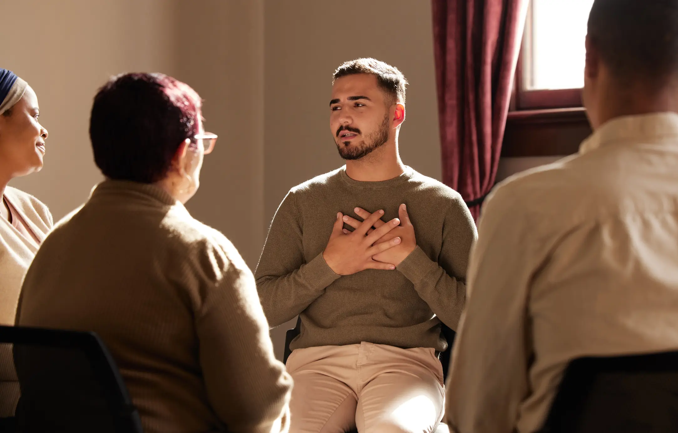 A man shares his struggles with his peers in group therapy.